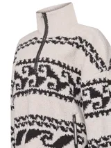 Sweater polar crudo con cuello alto y medio cierre, tejido con diseños étnicos en negro. Detalles de cuero en los bordes. Confeccionado con lana y alpaca.