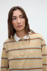 Remera polo de manga larga de algodón con textura suave, diseño a rayas horizontales en tonos beige, marrón y celeste, cuello blanco en contratono y media cartera de botones.