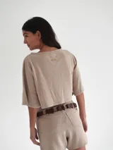 Top negro de tejido de punto con mangas cortas y bordado en el frente.