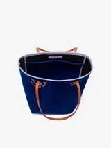 Bolso tipo tote de chenilla color verde oscuro con ribete amarillo. Tiene dos correas de hombro color crema, compartimento principal con bolsillos internos y apliques metálicos con el logo de la marca.