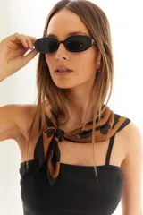 Lentes de sol negros con marco ovalado de policarbonato y protección UV400.