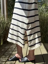 Vestido largo tejido a rayas horizontales azul marino y blancas, sin mangas, con cuello redondo y tajos laterales.