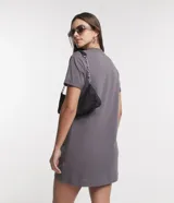 Vestido corto de cuello redondo y manga corta con dobladillo, confeccionado en tejido de punto de algodón. Presenta un diseño básico con un pequeño bolsillo aplicado en el pecho.