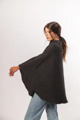 Capa de lana merino color gris oscuro con cuello alto y cierre frontal con botones de madera.