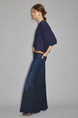 Pantalón de jean de tiro alto y pierna ultra ancha, confeccionado en denim confort con elastano y lavado azul oscuro. Presenta bolsillos traseros con bordado de alas y forrería estampada con el logo de la marca.