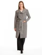 Chaqueta larga de tejido de punto con estampado de pata de gallo en blanco y negro. Presenta cuello de solapa, cierre frontal con lazo ajustable en la cintura y bolsillos aplicados en el frente.