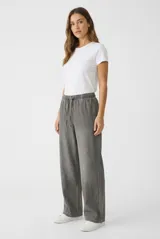 Pantalon fluido estilo denim de corte ancho, color gris, con cintura elastizada y cordón ajustable.