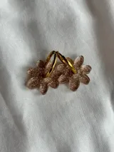 Aros de argolla dorada con dije colgante en forma de flor, fabricado en acrílico traslúcido con acabado brillante.