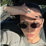 Lentes de sol con armazón metálico dorado de forma ovalada y cristales oscuros con protección UV400.