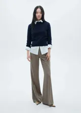Pantalón de vestir estilo flare con diseño de tiro medio y corte acampanado. Cuenta con trabillas en la cintura, cierre oculto de botón, gancho y cremallera, dos bolsillos laterales y dos bolsillos de ribete en la parte posterior.