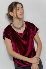 Remera de manga corta confeccionada en terciopelo, con cuello redondo y diseño simple. Una prenda versátil y elegante para elevar cualquier conjunto.