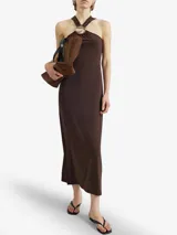 Vestido midi marrón con escote halter cruzado y detalle metálico circular en el frente. Confeccionado en mezcla de poliéster y elastano, de caída fluida y líneas minimalistas.