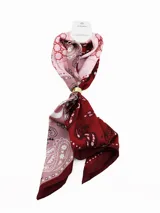 Pañuelo cuadrado de satén con estampado tipo bandana en tonos degradados de rosado y bordó, sujeto por una argolla metálica dorada.