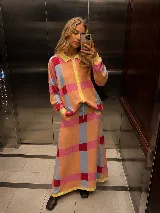 Saco oversize largo de punto con estampado geométrico a cuadros en tonos naranja, celeste, fucsia y amarillo. Presenta cuello polo, cierre frontal con botones y mangas largas con puños en contraste.