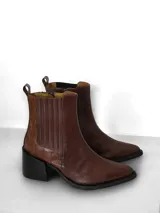 Bota de cuero color marrón con caña corta, taco cuadrado y cierre interno.