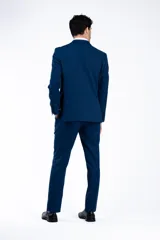 Ambo de corte slim fit compuesto por saco de dos botones con solapa clásica y pantalón de vestir a juego, en color azul con textura sutil.