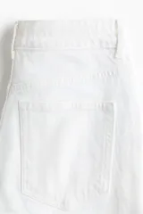 Jean de tiro alto con corte wide leg, confeccionado en denim de algodón con leve elasticidad. Presenta diseño clásico de cinco bolsillos, cierre frontal con botón y corte holgado desde el muslo hasta el bajo.