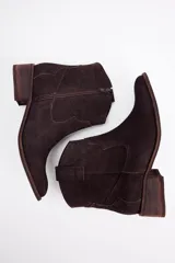 Botinetas estilo texano de cuero vacuno, color negro, con taco bajo cuadrado y diseño de caña corta.