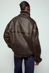 Chaqueta bomber de cuello alto con forro interior de pelo sintético. Presenta cierre frontal con botones, bolsillos delanteros y bajo ajustable con cordones.