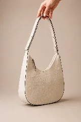 Cartera hobo de cuero color rojo con silueta curva de media luna, cierre superior y correa de hombro ajustable.