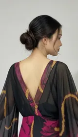 Vestido largo de tul translúcido con estampado de líneas orgánicas en tonos magenta, vino y dorado, escote cruzado y mangas amplias.