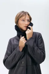 Campera de cuero tipo lambskin con diseño de paneles, cuello con solapas de piel sintética, cierre frontal con botones y bolsillos laterales.