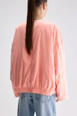 Campera reversible de calce relajado con diseño de animal print tipo leopardo, cierre frontal y bolsillos laterales.