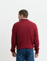 Sweater de punto color tostado, con cuello alto y cierre frontal parcial con botones. Diseño de manga larga con puños y ruedo acanalados.