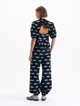 Pantalón tipo babucha negro con estampado de labios azules, confeccionado en jacquard. Cuenta con cierre, doble gancho pantalonero y botón interno, puño elástico en el ruedo, bolsillos laterales y bolsillos ojal traseros.