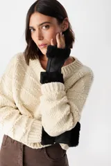 Mitones de cuero napalan con interior de piel sintética tipo corderito. Presentan costuras visibles y detalle de chapita metálica con logo.