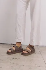 Sandalias marrones de cuero con plataforma y tiras con hebillas ajustables.