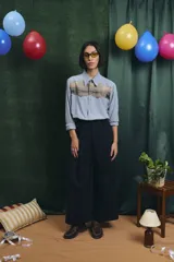 Camisa negra de manga larga con canesú frontal estampado con motivos artísticos de bodegón. Incluye una corbata fina integrada del mismo tono.