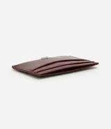 Billetera compacta de poliuretano color bordó, de diseño slim con compartimentos para tarjetas y aplicación metálica frontal con el logo de la marca Satinato.