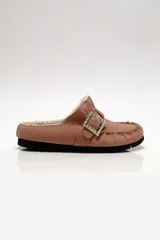 Mule de mujer color rosado, estilo mocasín, con forro interior de borrego (shearling) y hebilla decorativa cuadrada con incrustaciones de pedrería brillante.