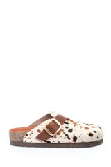 Zueco de cuero con estampa tipo animal print de vaca, con tira de ajuste marrón y hebilla metálica. Plantilla anatómica y suela de corcho y goma.