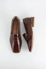 Mocasín clásico de cuero con textura croco acharolada, con taco cuadrado bajo símil madera.