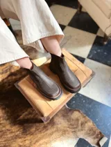 Bota Chelsea de cuero color marrón chocolate con elástico lateral negro y suela track color negro.