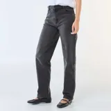 Jean de corte recto y tiro medio, confeccionado en denim de algodón color negro. Presenta diseño clásico de cinco bolsillos, cierre frontal con cremallera y botón metálico.