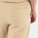 Bermuda de punto grueso color beige, de diseño liso, con bolsillos laterales y cintura elástica.