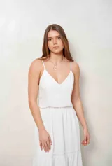 Vestido largo blanco de tirantes finos, con escote en V y detalles de inserciones de encaje broderie en la cintura y en la falda escalonada.