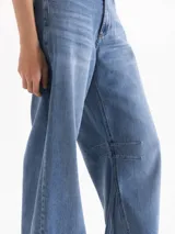 Jeans wide leg de tiro medio-bajo en denim celeste claro, con recortes y pinzas en las piernas que aportan movimiento y una caída fluida, confeccionado en algodón suave y flexible.