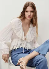Jeans de tiro medio con diseño flare y bajo deshilachado, con cinco bolsillos, presillas para cinturón y cierre frontal con cremallera y botón.