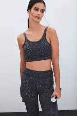 Top deportivo con estampado animal print en tonos grises, de escote redondo y tirantes anchos. Presenta una banda elástica en la base para mayor soporte.