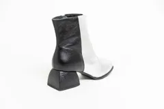 Botas cortas de cuero negro, con punta cuadrada y cierre lateral.