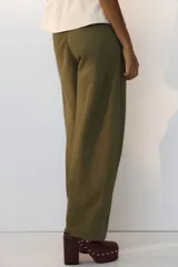 Pantalón de sarga de algodón verde militar, de tiro alto con piernas estilo barrel y costuras frontales destacadas. Cuenta con cierre de cremallera y botón oculto, bolsillos discretos en las costuras laterales y bolsillos traseros insertados.