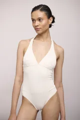 Malla enteriza negra con escote halter y paneles de tul transparente en la zona del abdomen y laterales.