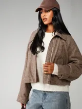 Chaqueta corta de corte recto con estampado de cuadros pequeños en tonos marrones y beige. Presenta cuello alto, mangas largas y cierre frontal oculto.