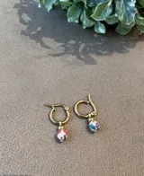 Aros de argolla dorada de acero quirúrgico con dije redondo de fimo blanco con flores de colores y bolita dorada.