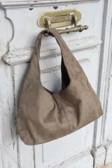 Cartera tipo hobo de gamuza negra, con diseño minimalista y asa integrada.