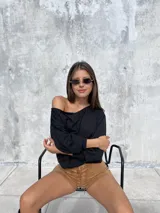 Short de tiro alto confeccionado en tela tipo gamuza scuba, con detalle de cordones frontales cruzados y ojales metálicos. Presenta un diseño ajustado y elástico que se adapta a la silueta.